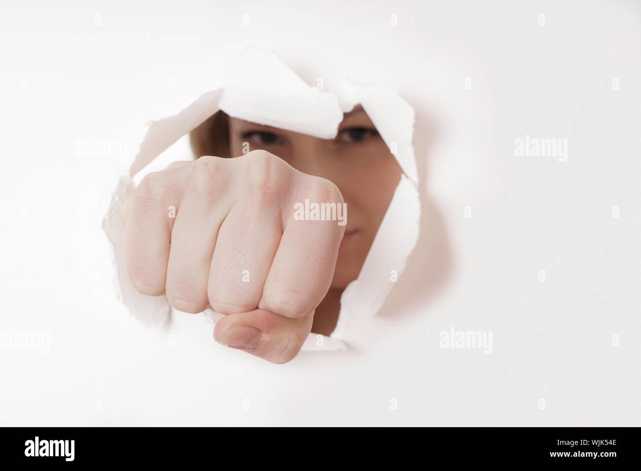 Close-up Of Woman Tearing Paper With Fist Stock Photo