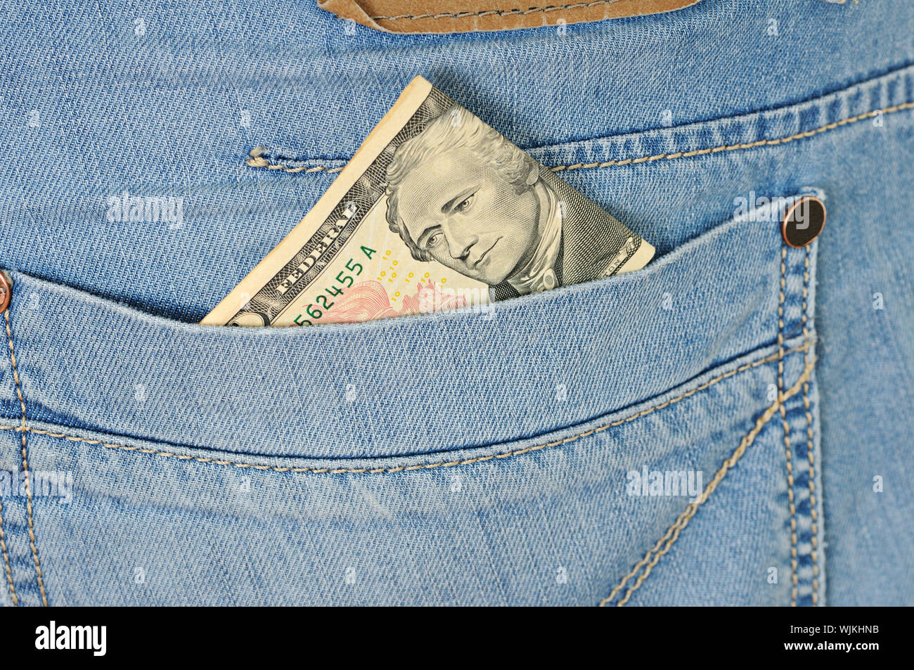 Ten dollars stick out of a pocket of  blue jeans Stock Photo