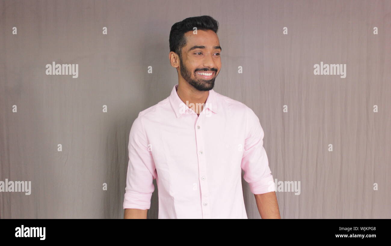 Smiling Young Man Standing Against Wall Stock Photo - Alamy
