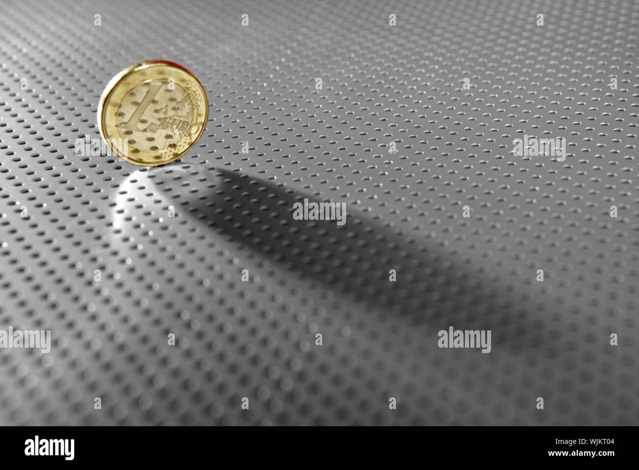 One euro coin currency close up over hole silver pattern background ...