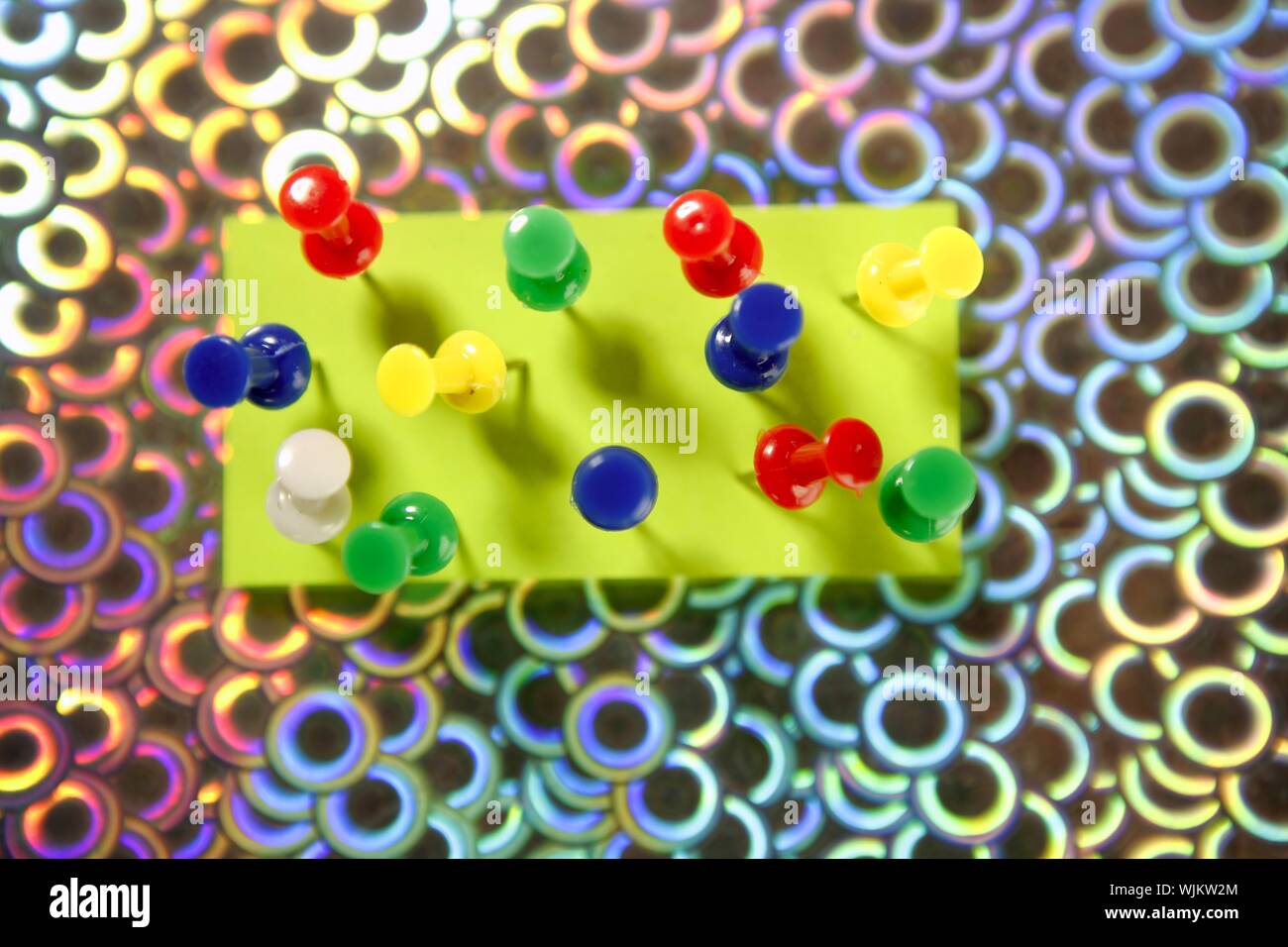 adhesive color notes with colorful pin over holographic background