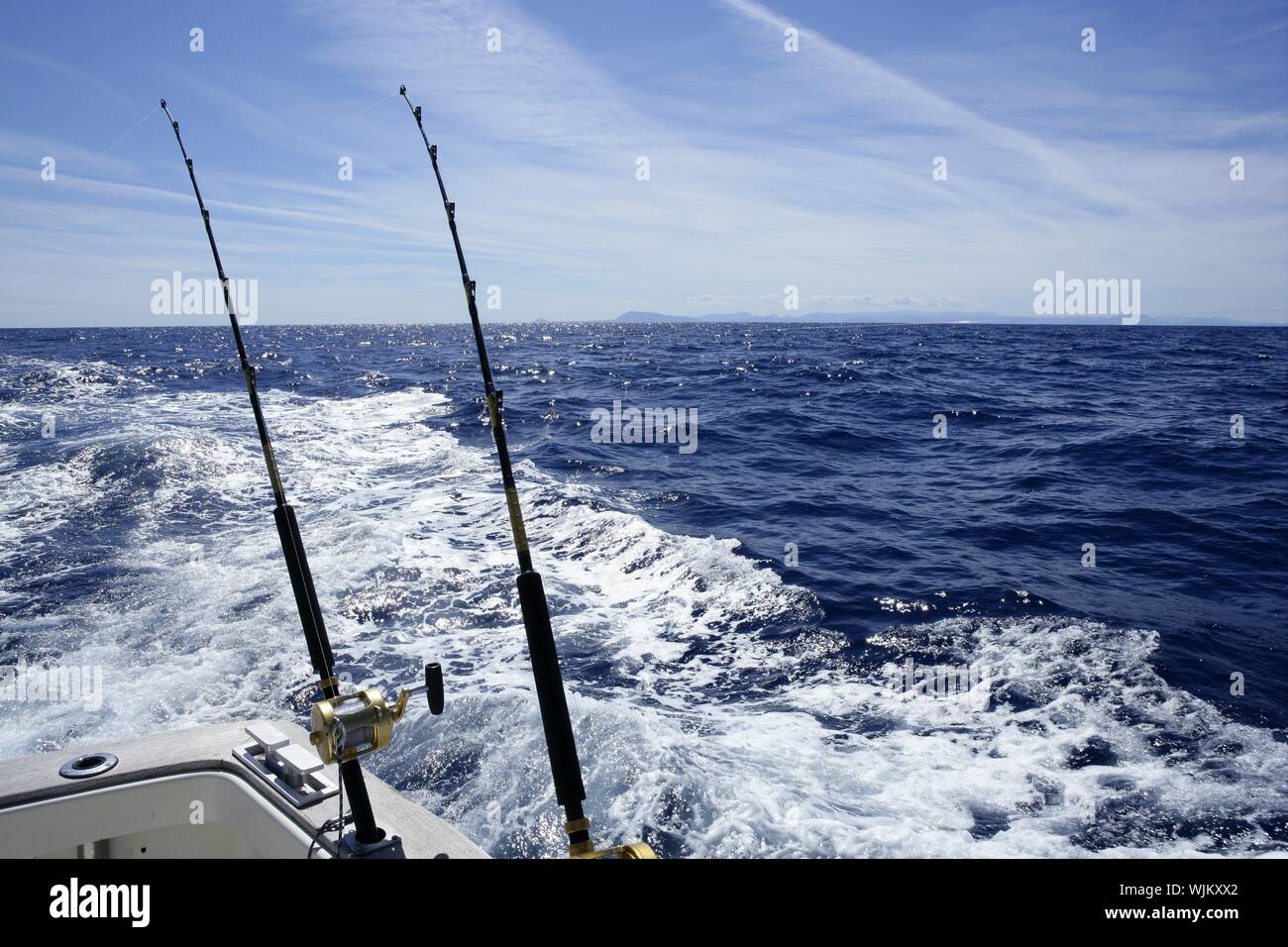 Fishing on the boat with trolling rod and reel. Blue Mediterranean sea  Stock Photo - Alamy