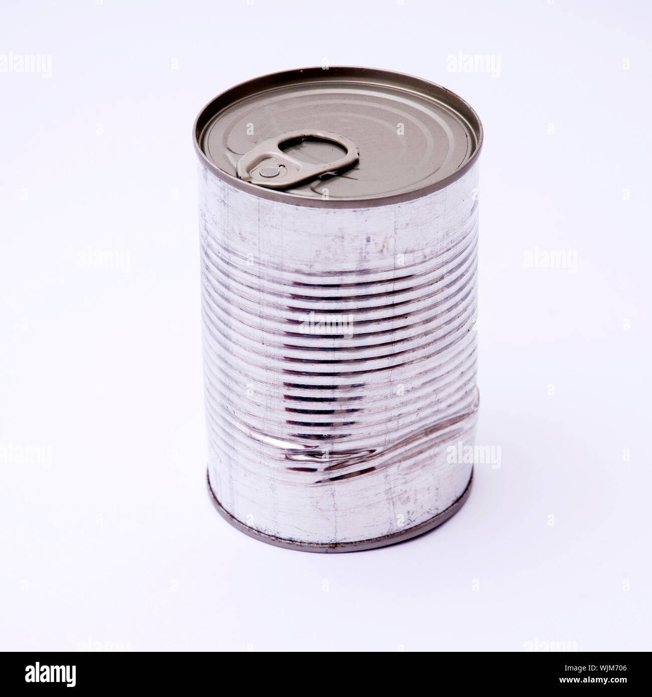 Close-up Of Dented Can Against White Background Stock Photo