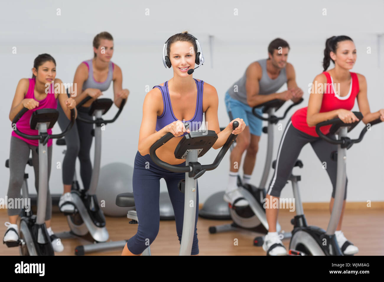 Portrait of fit young people working out at spinning class in gym Stock ...