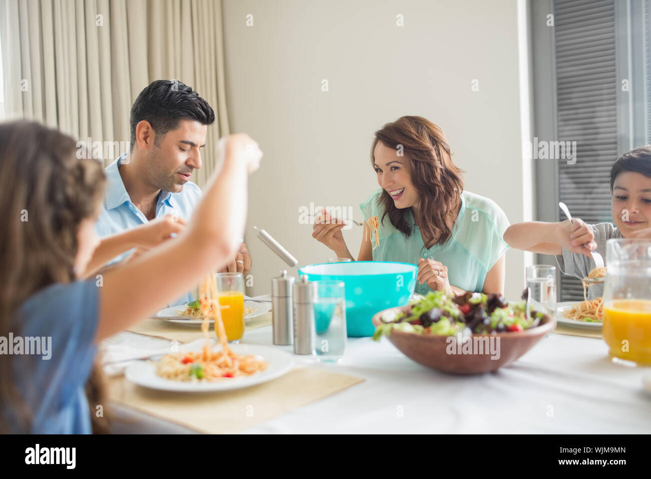 View of a family of four sitting at dining table in the home Stock