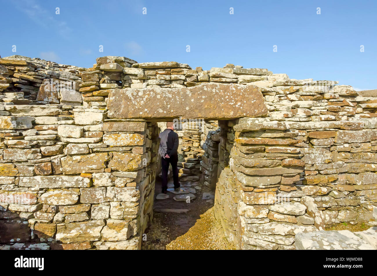 Broch of Gurness Entrance Orkney Islands, Scotland. Person inside for size comparison. A broch is a rounded Iron Age tower unique to Scotland. Stock Photo