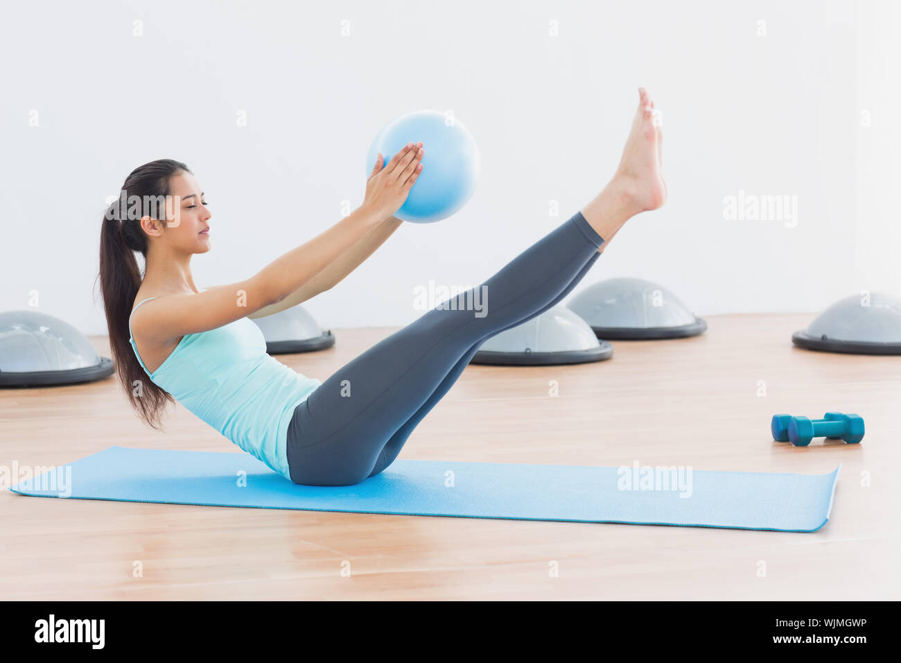 Full length side view of a sporty young woman stretching body in ...