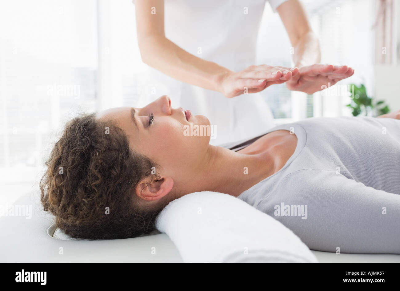 Attractive young woman having reiki treatment in health spa Stock Photo ...