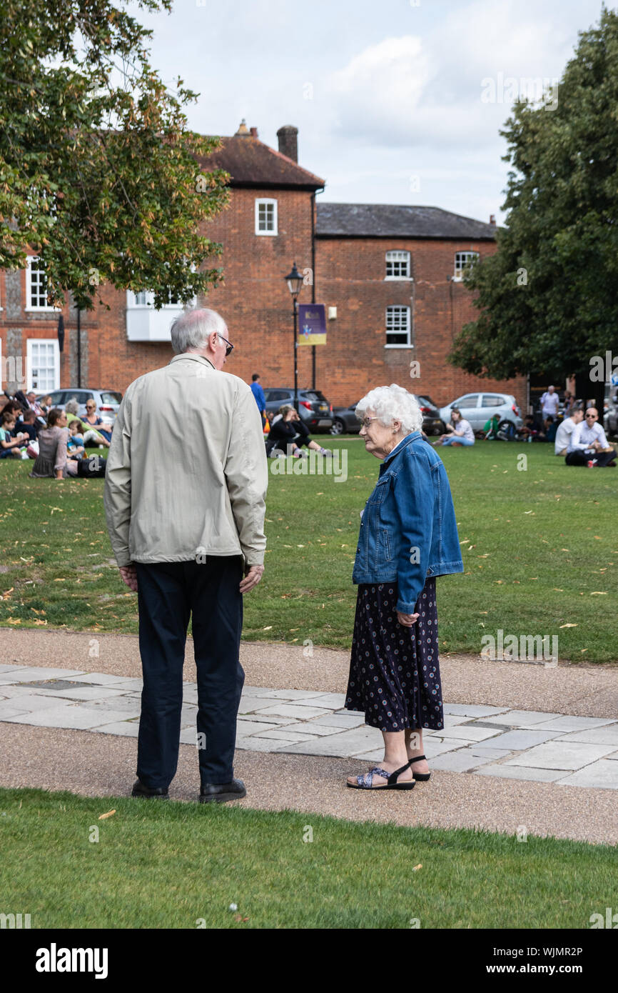 An elderly man and woman standing in a park talking Stock Photo