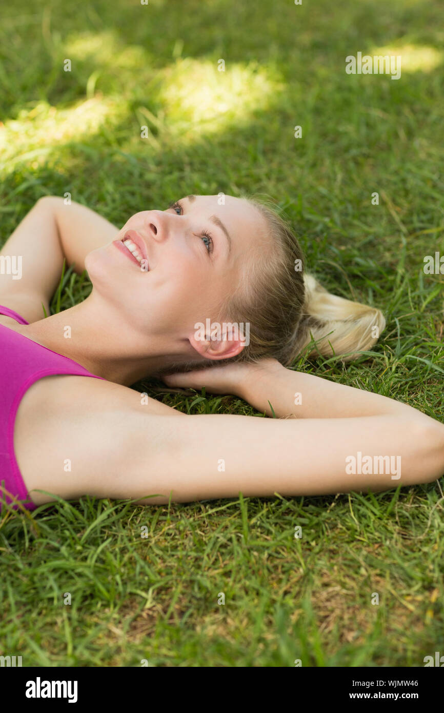 Relaxed beautiful young woman lying on grass in the park Stock Photo ...