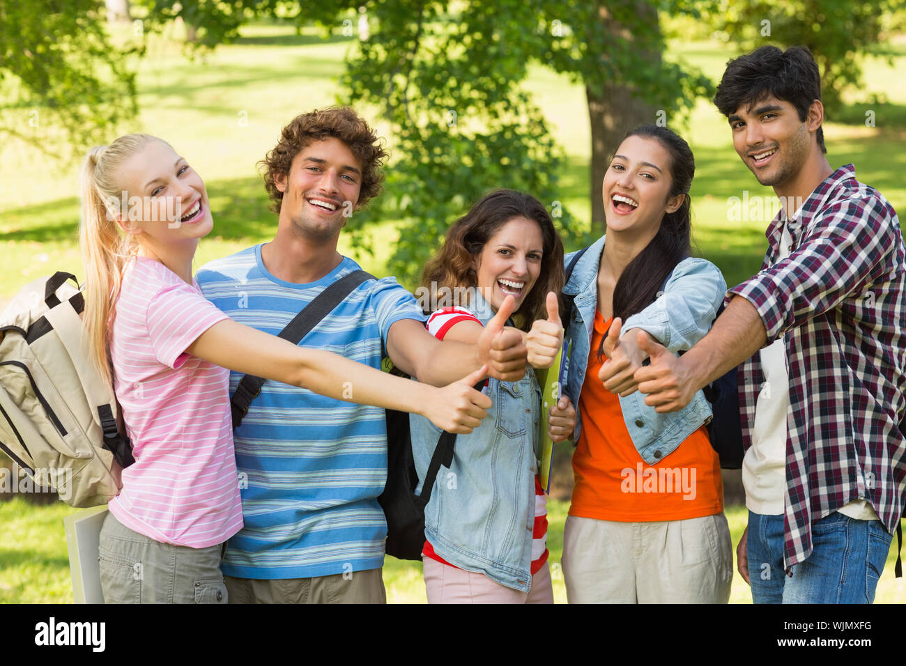 Group portrait of happy college friends gesturing thumbs up in the campus  Stock Photo - Alamy, image size:1300x956