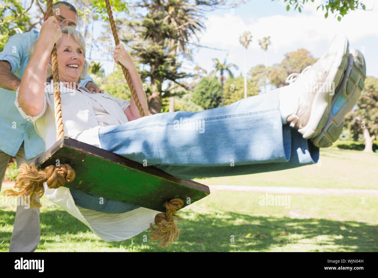 Mature woman swinging in park hi-res stock photography and images - Alamy