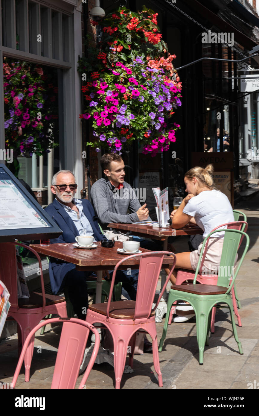 Winchester, Hampshire, UK people sitting outside a British cafe or coffee shop in the summer enjoying the sun Stock Photo