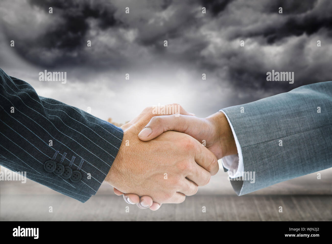 Composite image of business handshake against technological background with hexagons Stock Photo