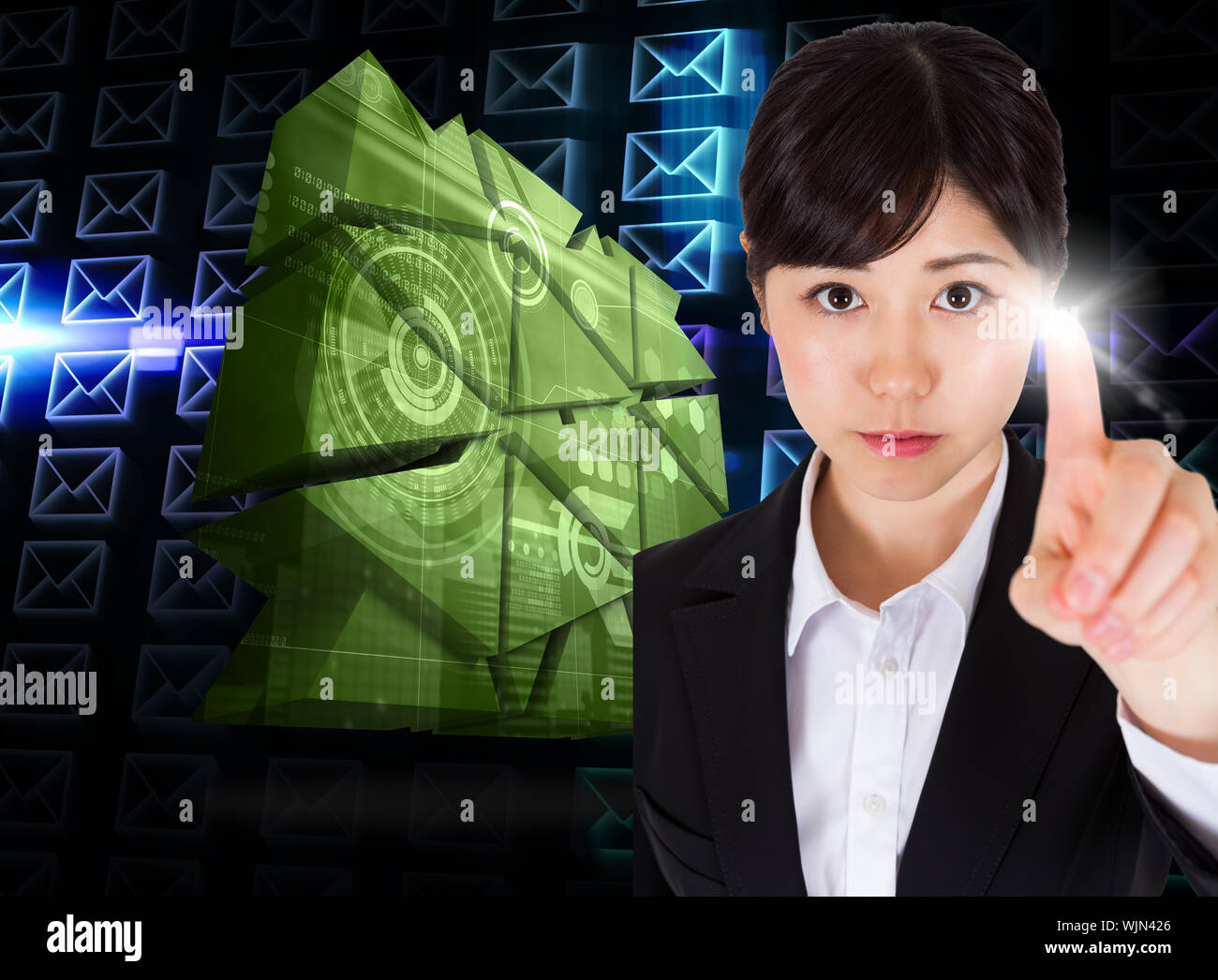 Focused businesswoman pointing against glowing envelopes on black background Stock Photo