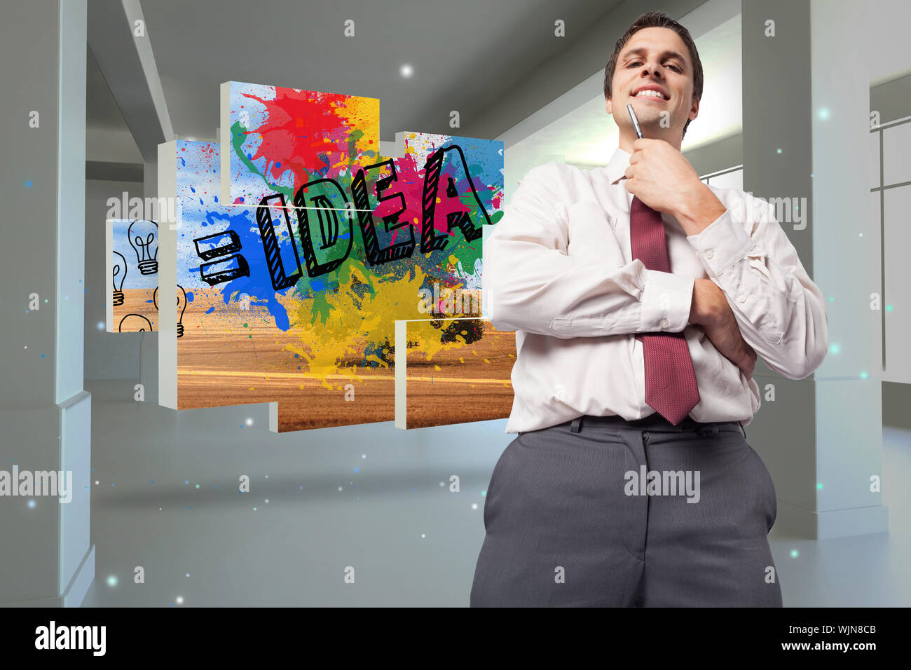 Thoughtful businessman holding pen to chin against screen in room with sparks Stock Photo
