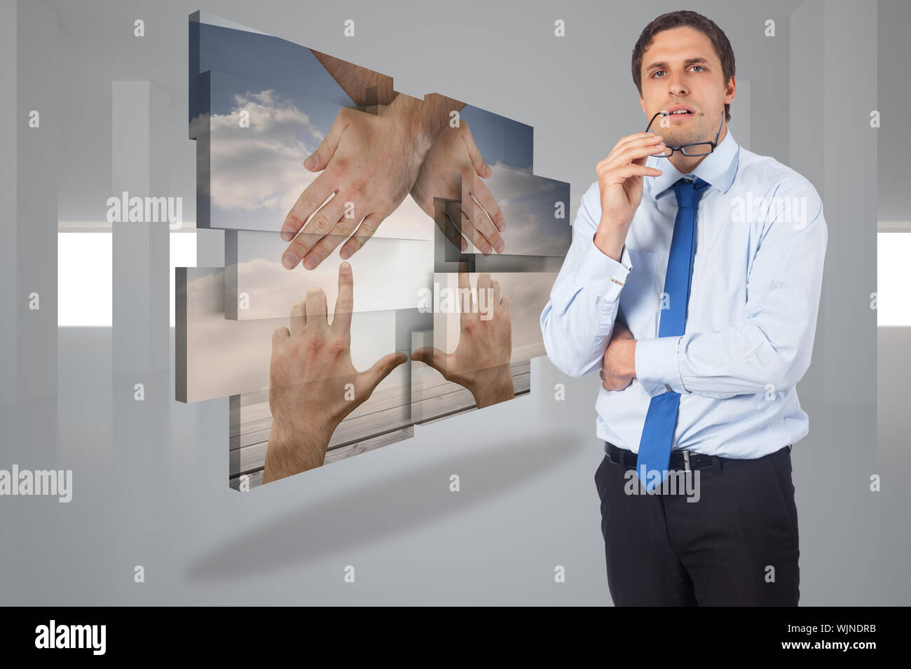 Thinking businessman biting glasses against digitally generated room Stock Photo