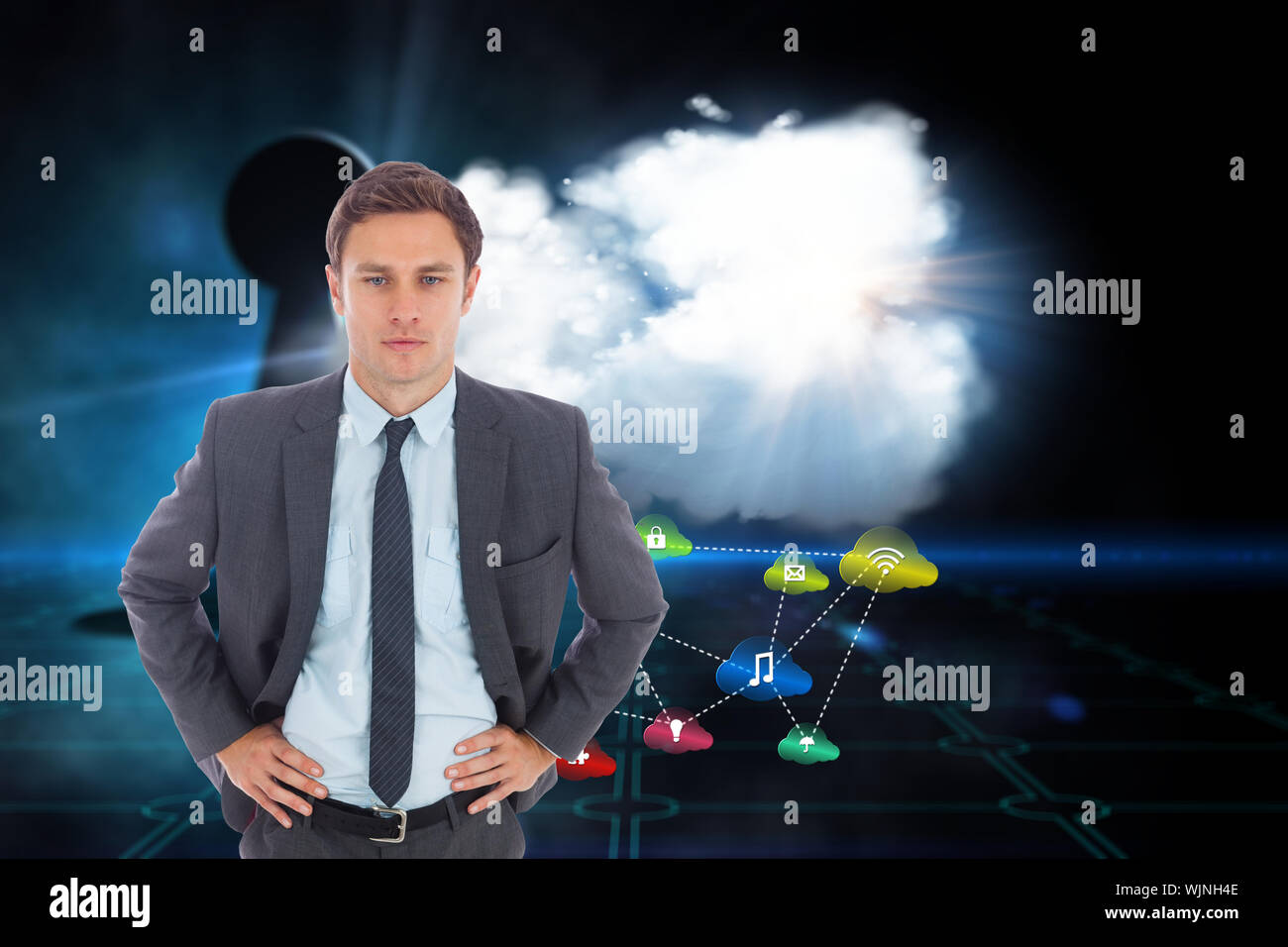 Serious businessman standing with hands on hips against keyhole on technological black background Stock Photo