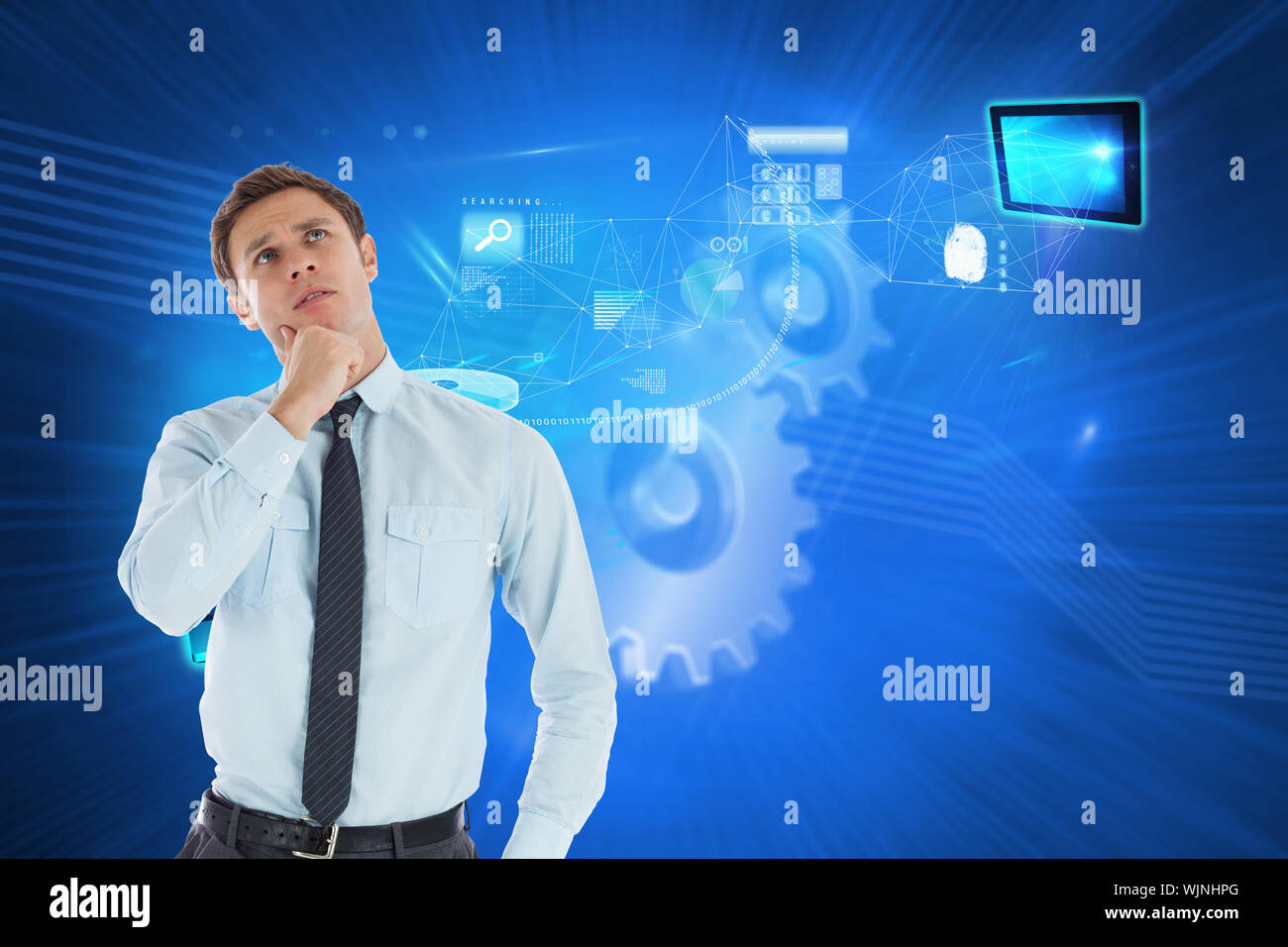 Thoughtful businessman with hand on chin against shiny cogs on blue background Stock Photo