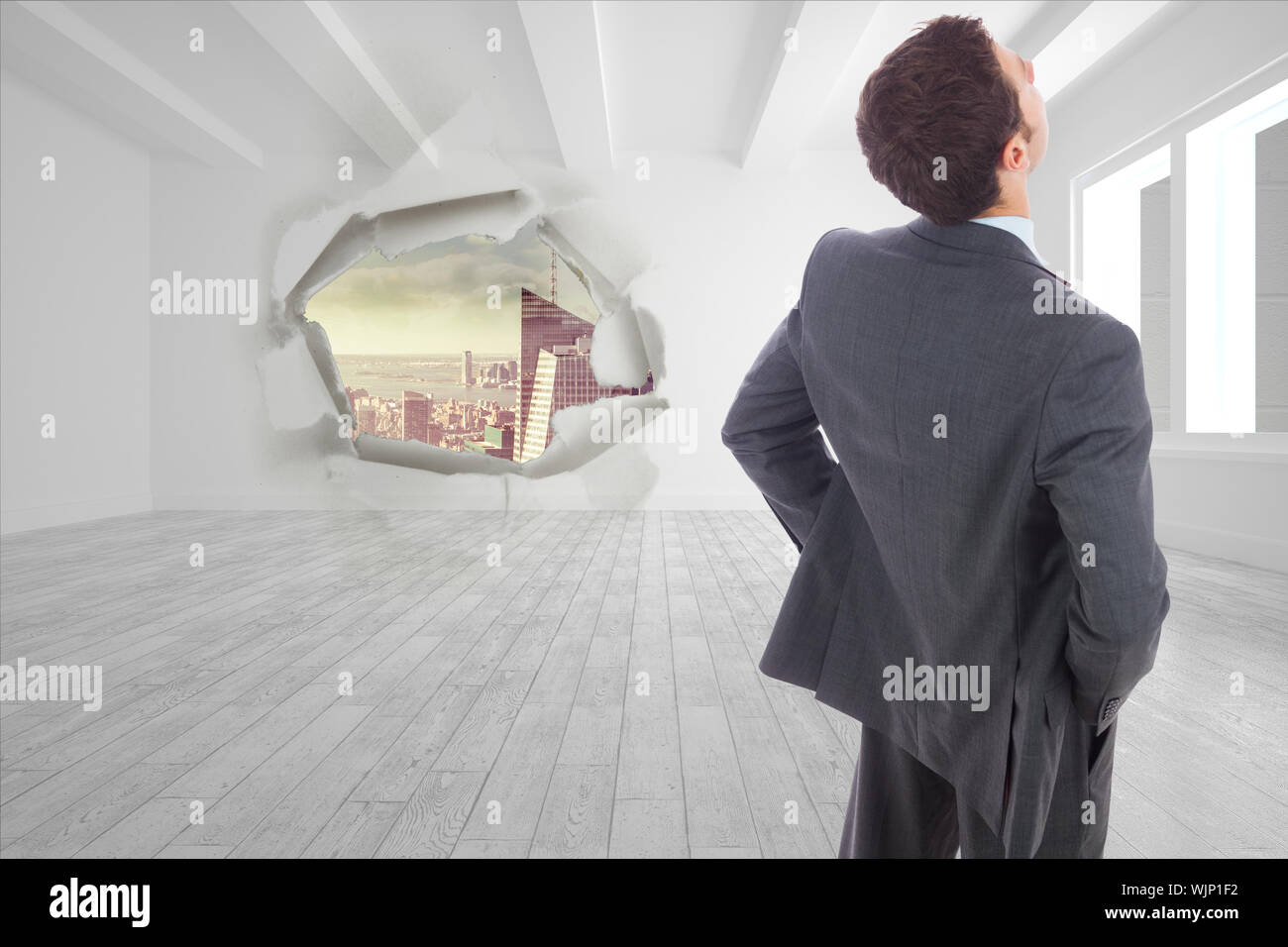 Open Rip In Wall Businessman standing with hands on hips against rip on wall showing ...