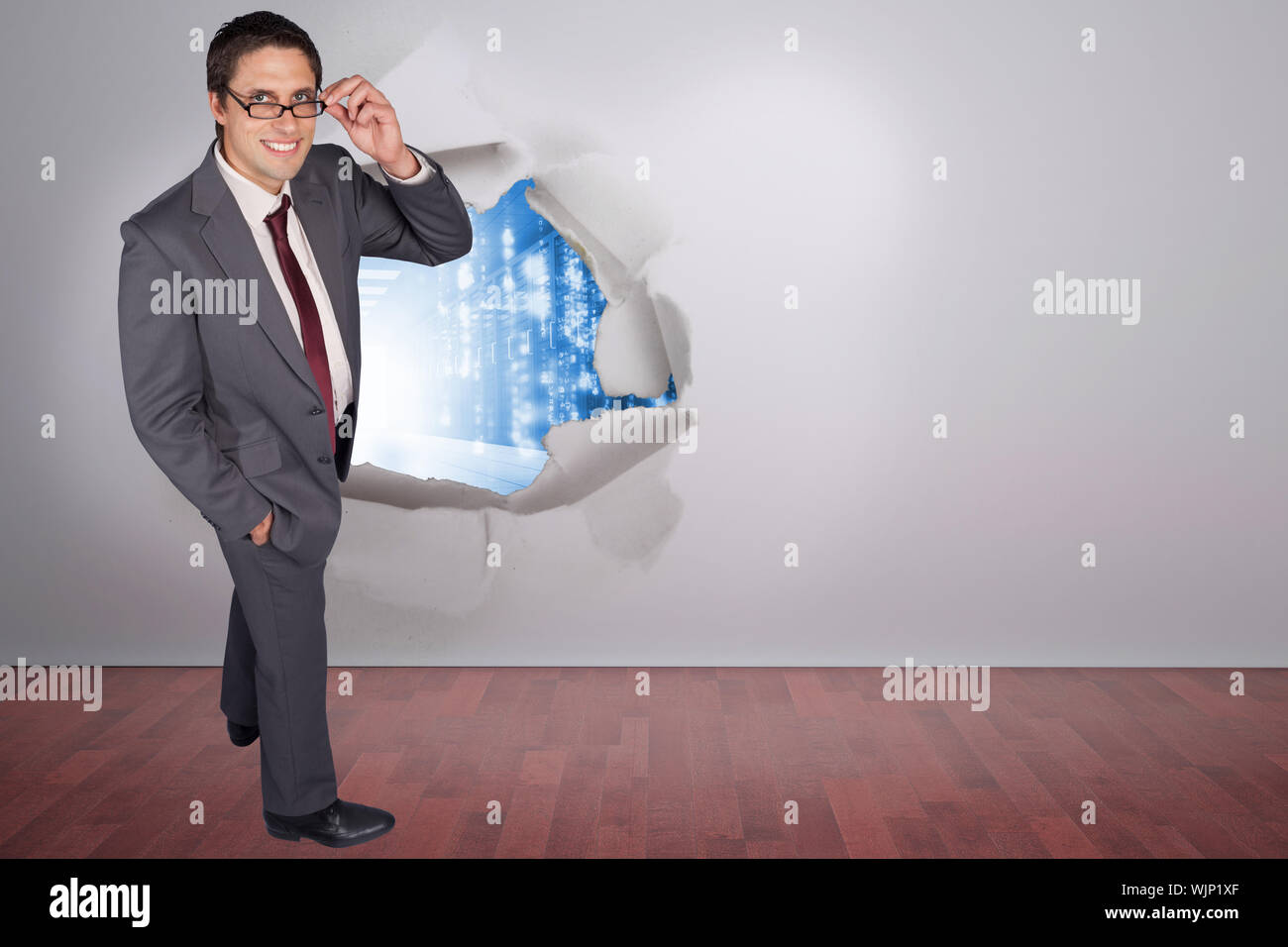 Thinking businessman touching his glasses against rip on wall showing ...
