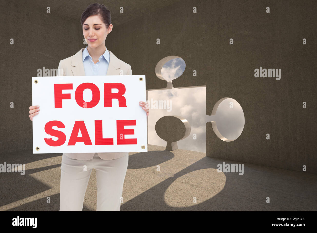 Estate agent holding for sale sign against jigsaw door in dark room