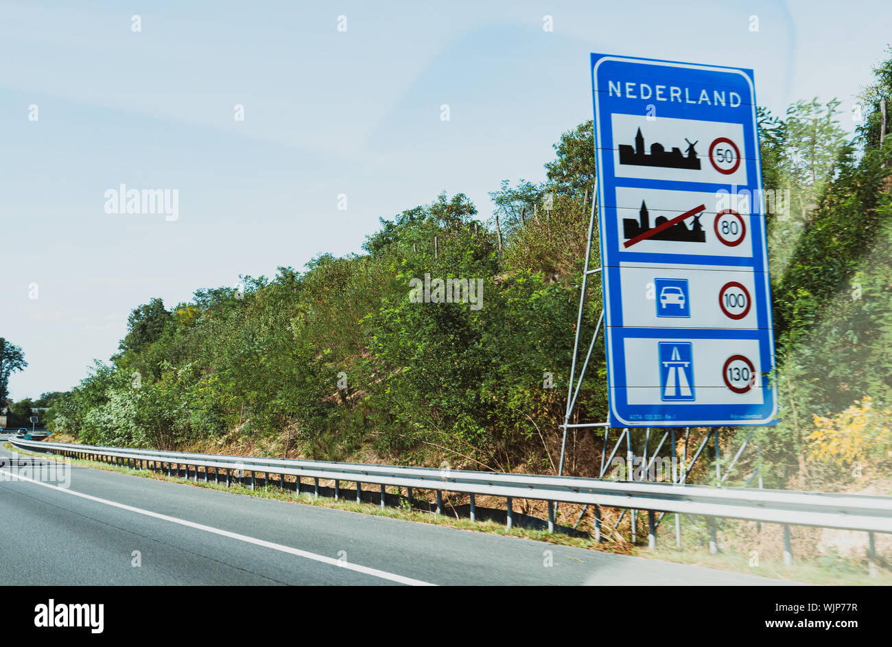 Nederland text at the border between Germany and Netherlands with speed limits in city, highway and rural roads Stock Photo