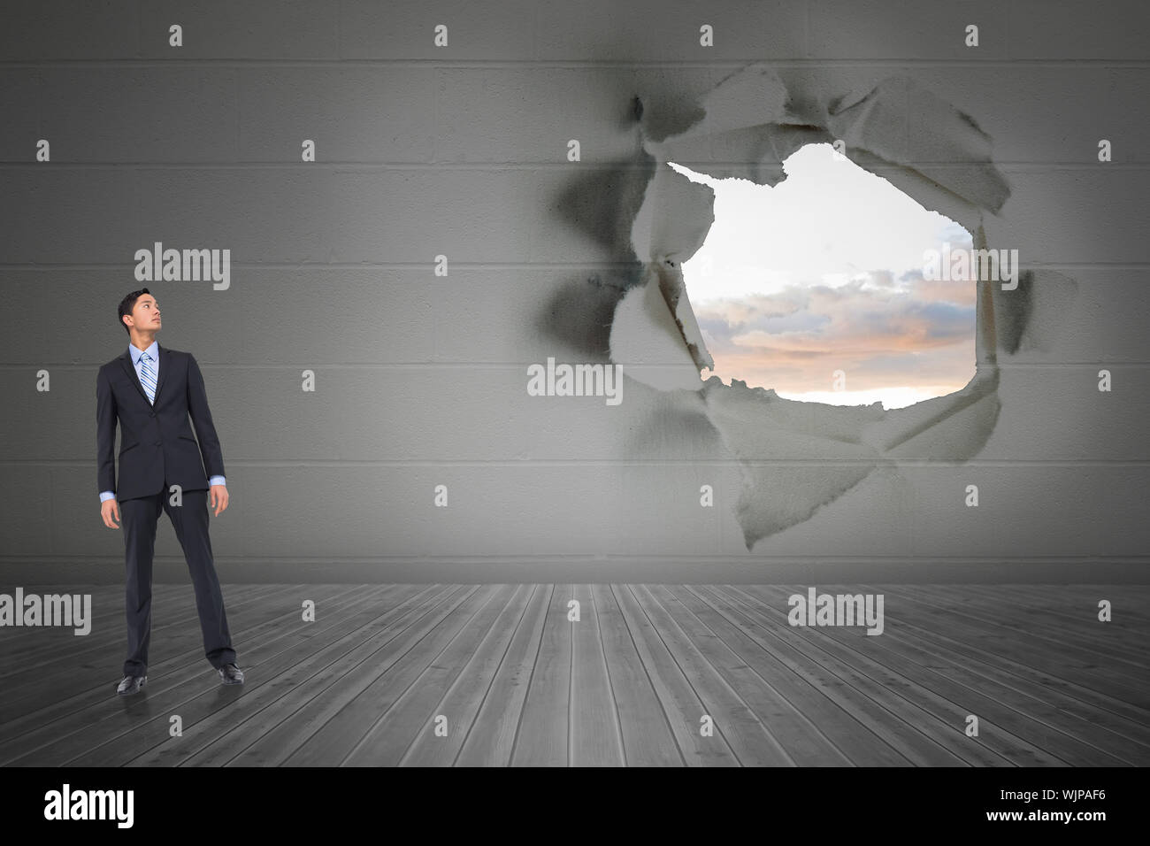 Open Rip In Wall Serious asian businessman against rip on wall showing bright sky Stock ...