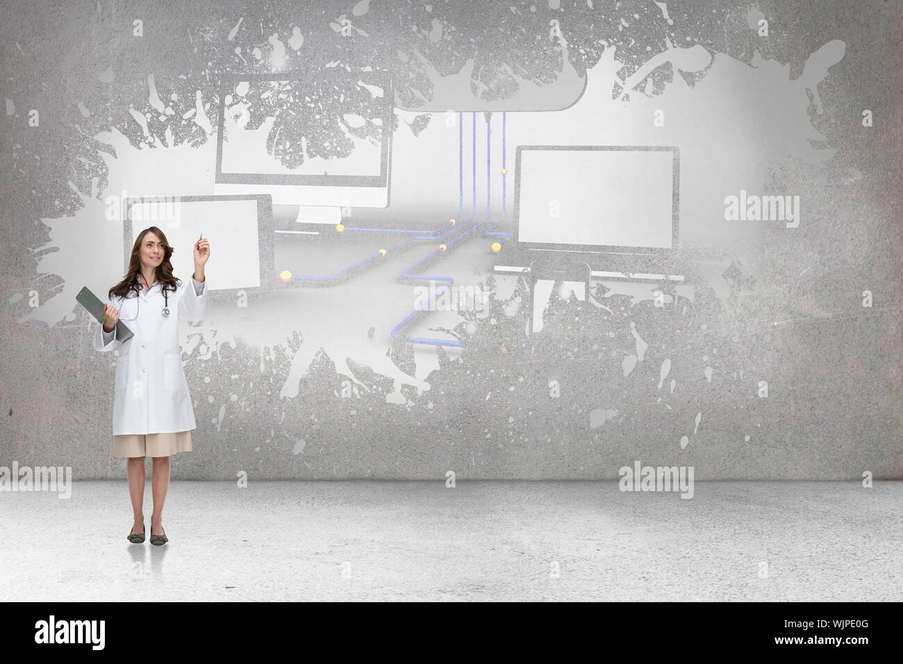 Smiling doctor pointing against splash on wall revealing cloud computing concept Stock Photo
