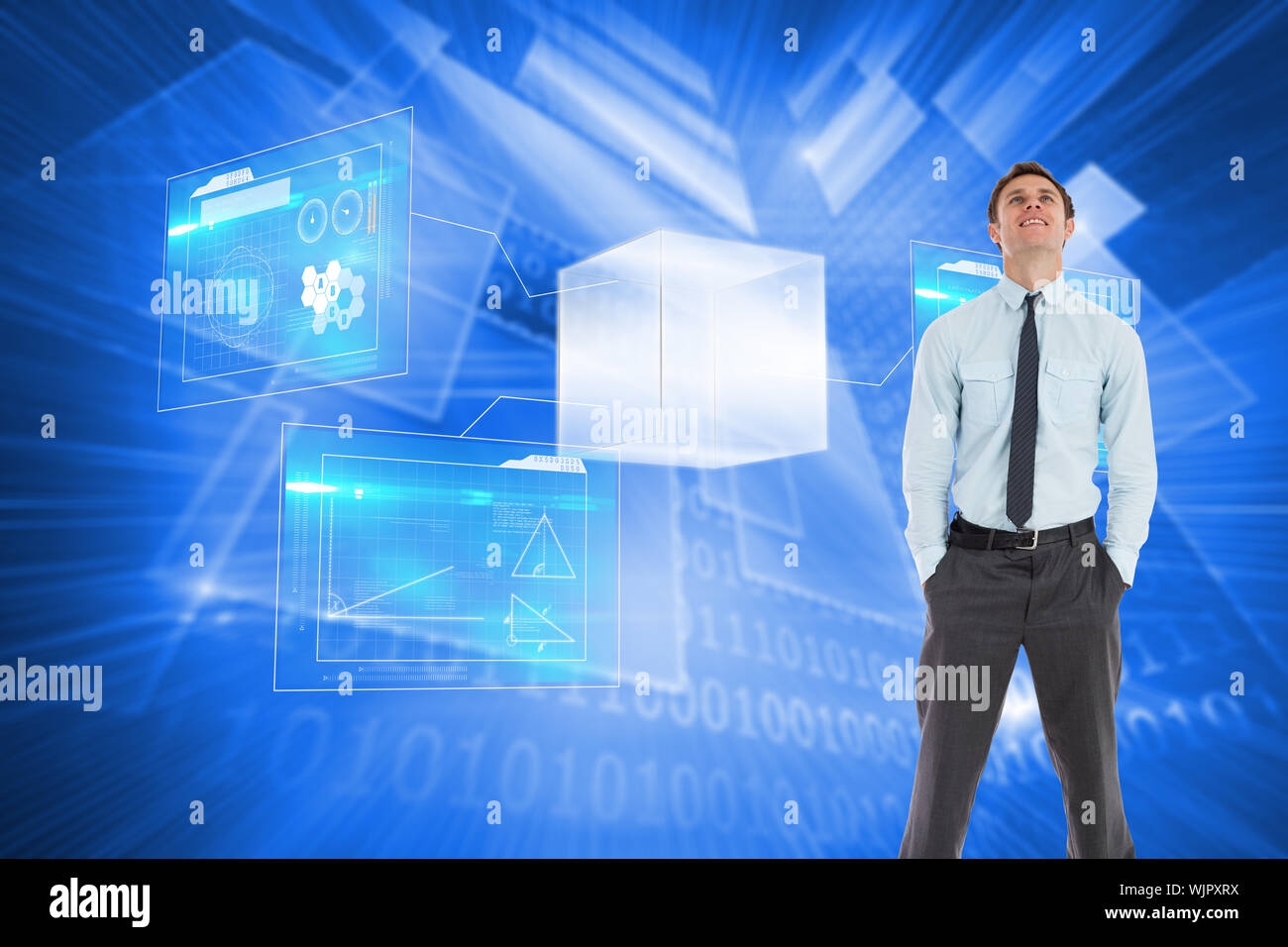 Smiling businessman standing with hands in pockets against shiny technological background Stock Photo