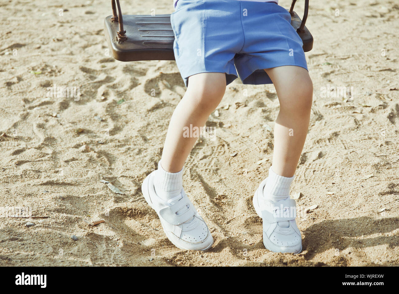 Little child on a swing in the park. Stock Photo