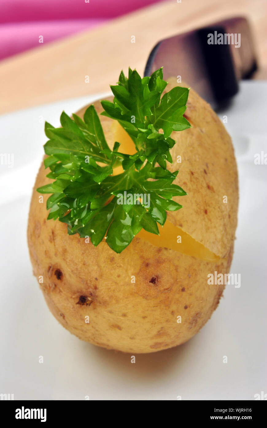 boiled organic potato with parsley and a knife Stock Photo Alamy