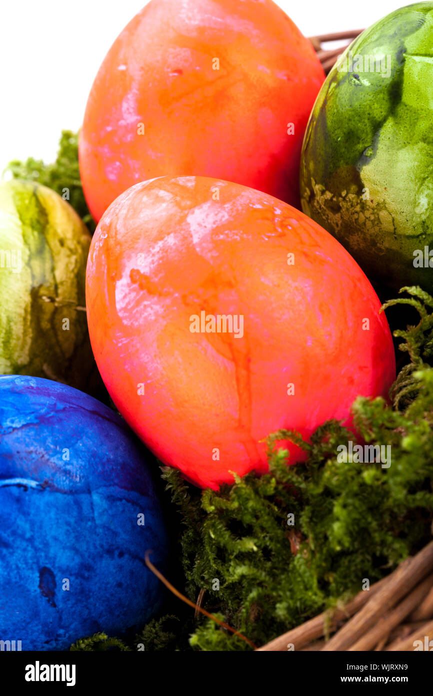 Rustic wicker basket of brightly coloured hand-painted traditional Easter Eggs with a marbled pattern nestling in a bed of green moss, high angle view Stock Photo