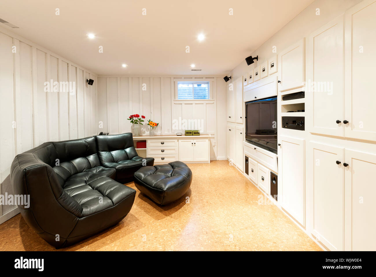Finished basement of residential home with entertainment center, couch