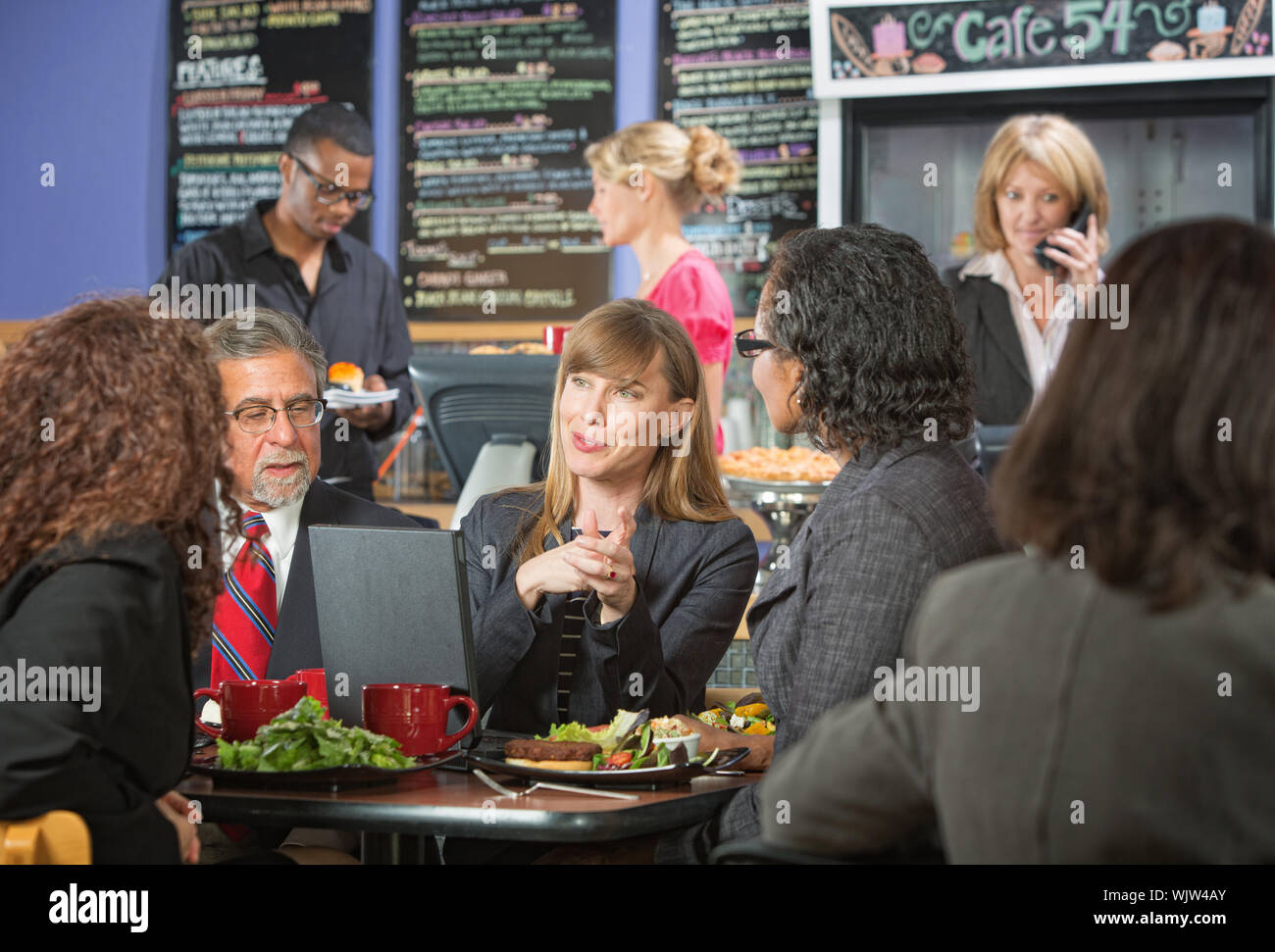 Smiling female executive eating lunch with coworkers Stock Photo Alamy