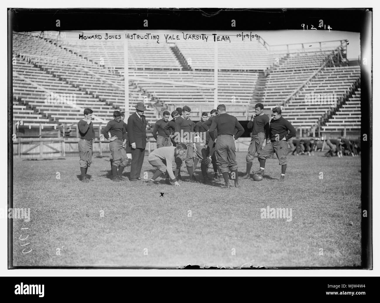 Howard Jones instructing Yale Varsity football team on playing field