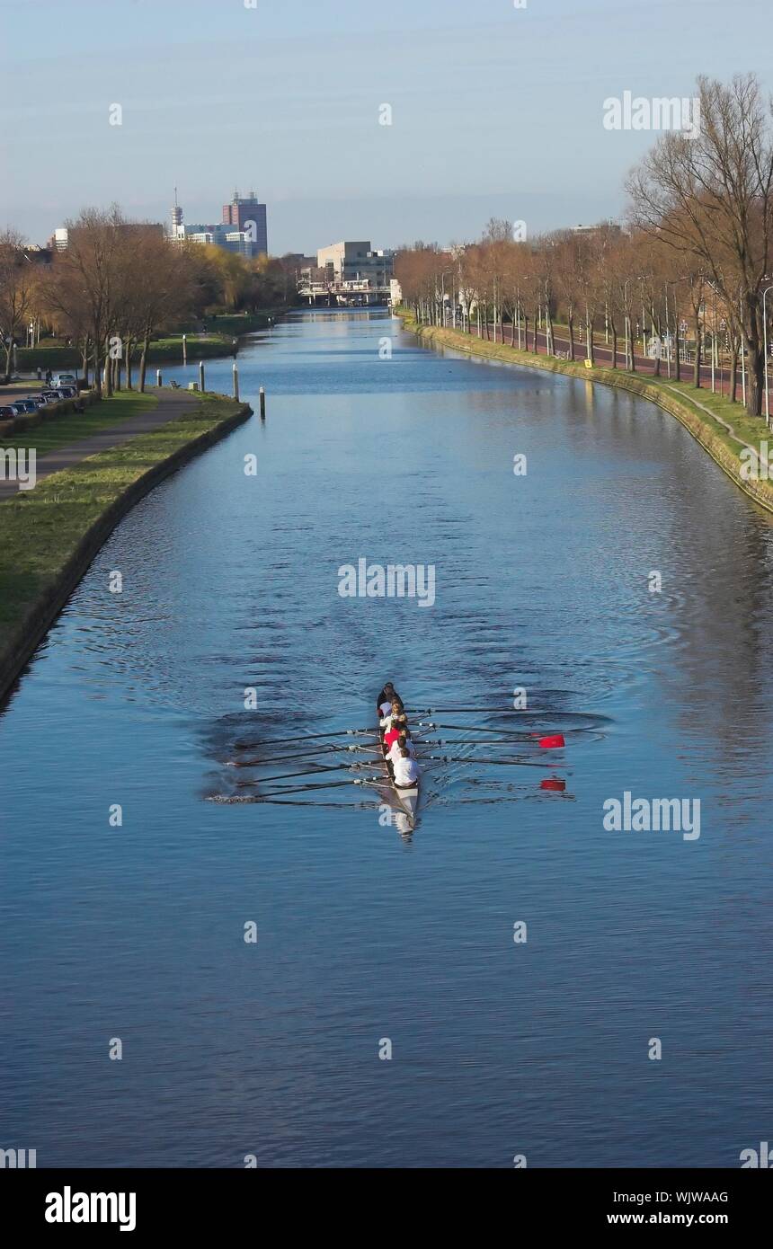 A group of rowers paddling along a Dutch canal near The Hague Stock