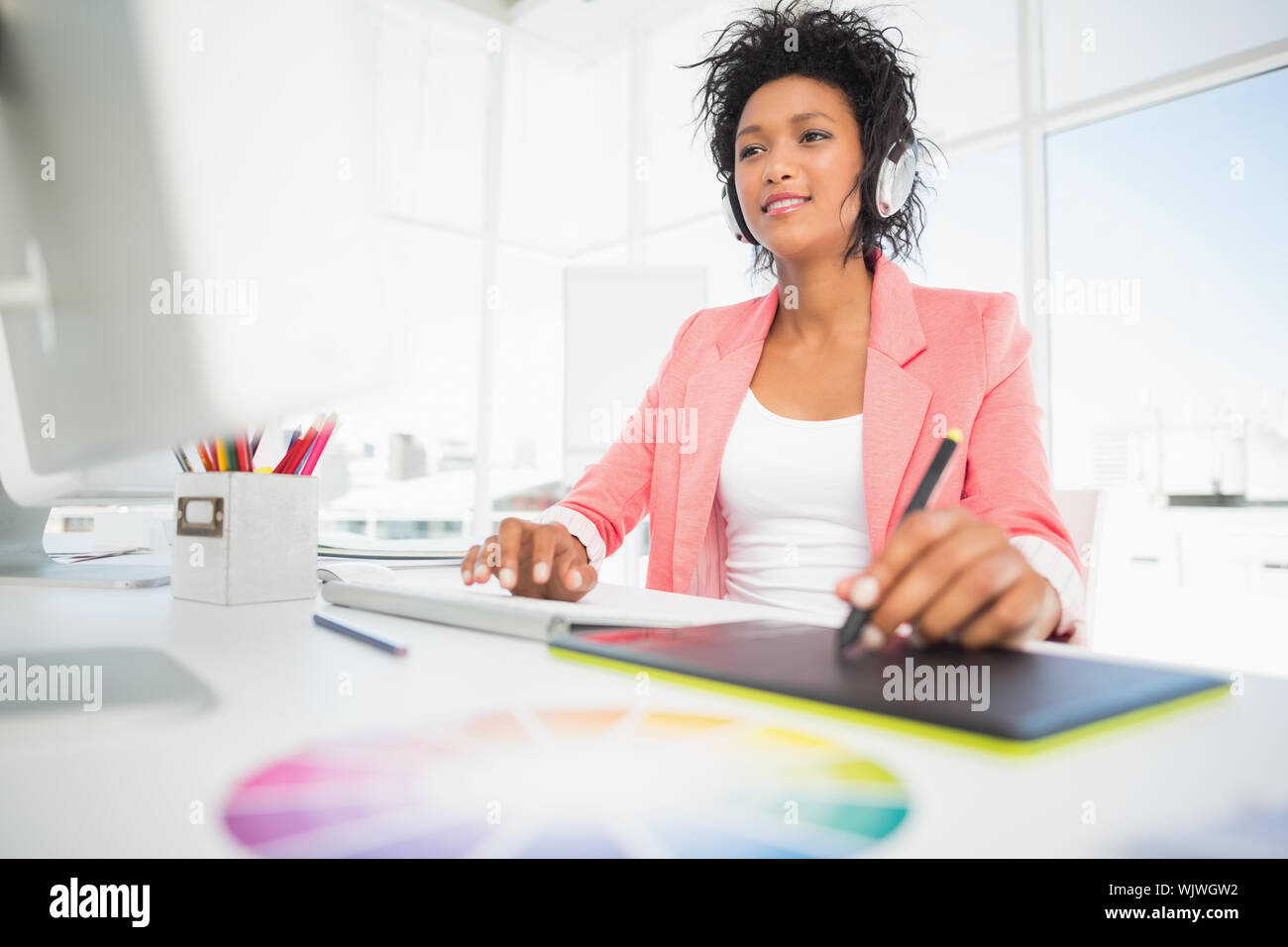 Casual female photo editor using graphics tablet in a bright office Stock Photo