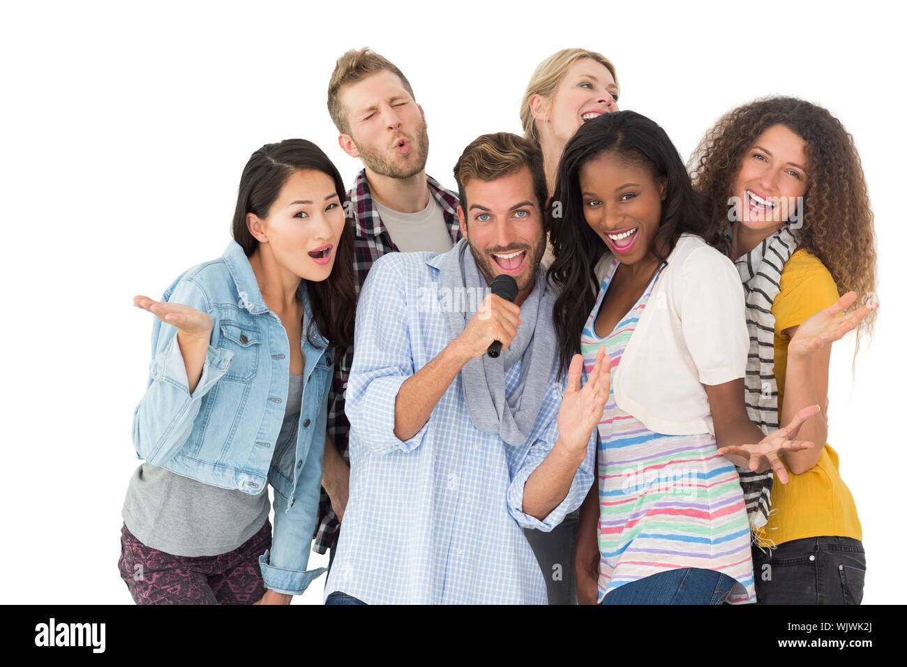 Happy group of friends having fun doing karaoke on white background Stock Photo