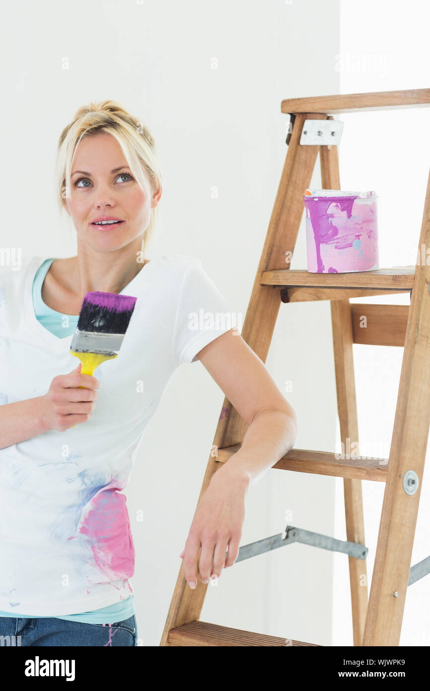 Thoughtful woman holding paint brush hi-res stock photography and ...