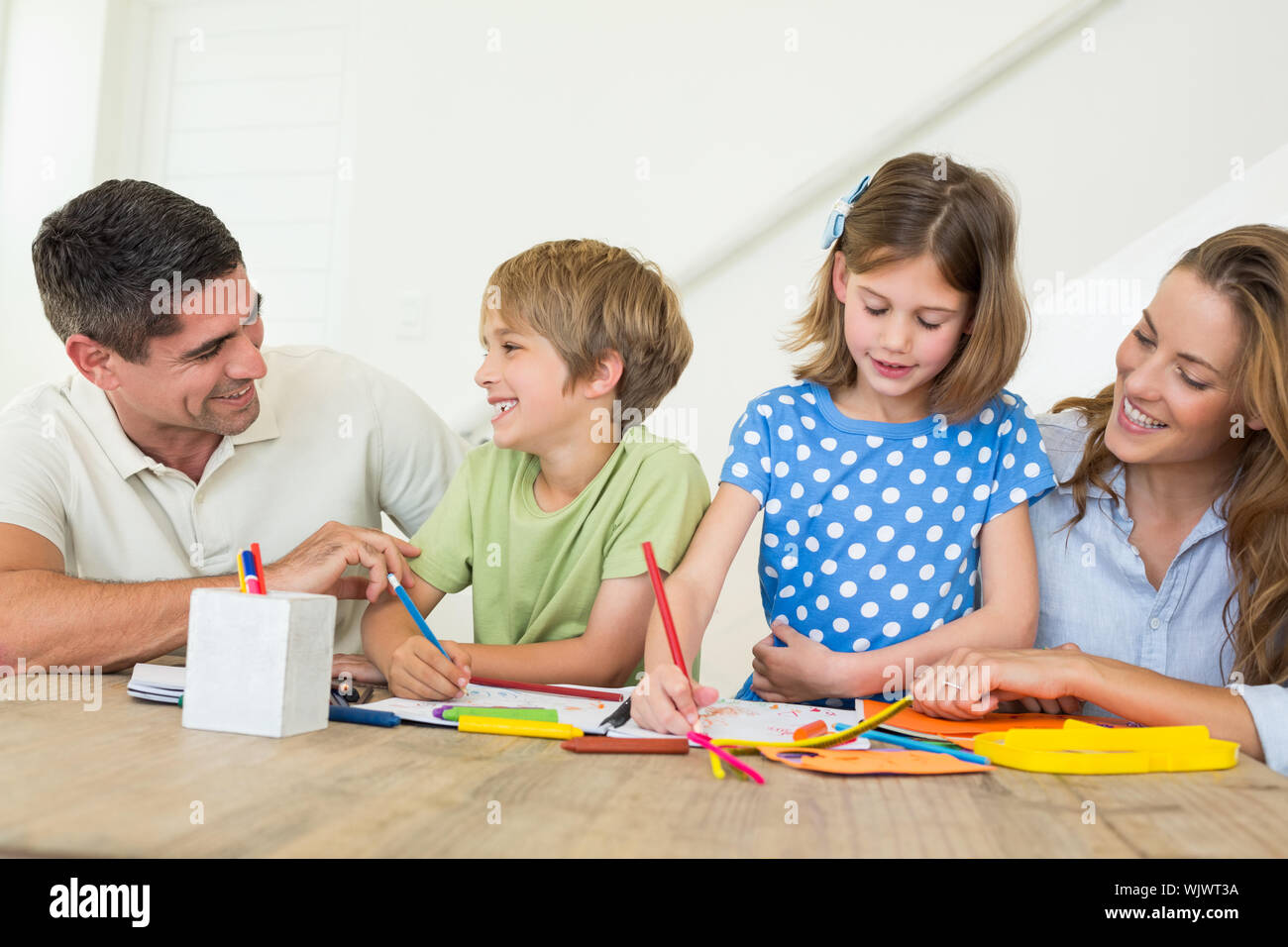Family of four coloring at home Stock Photo - Alamy
