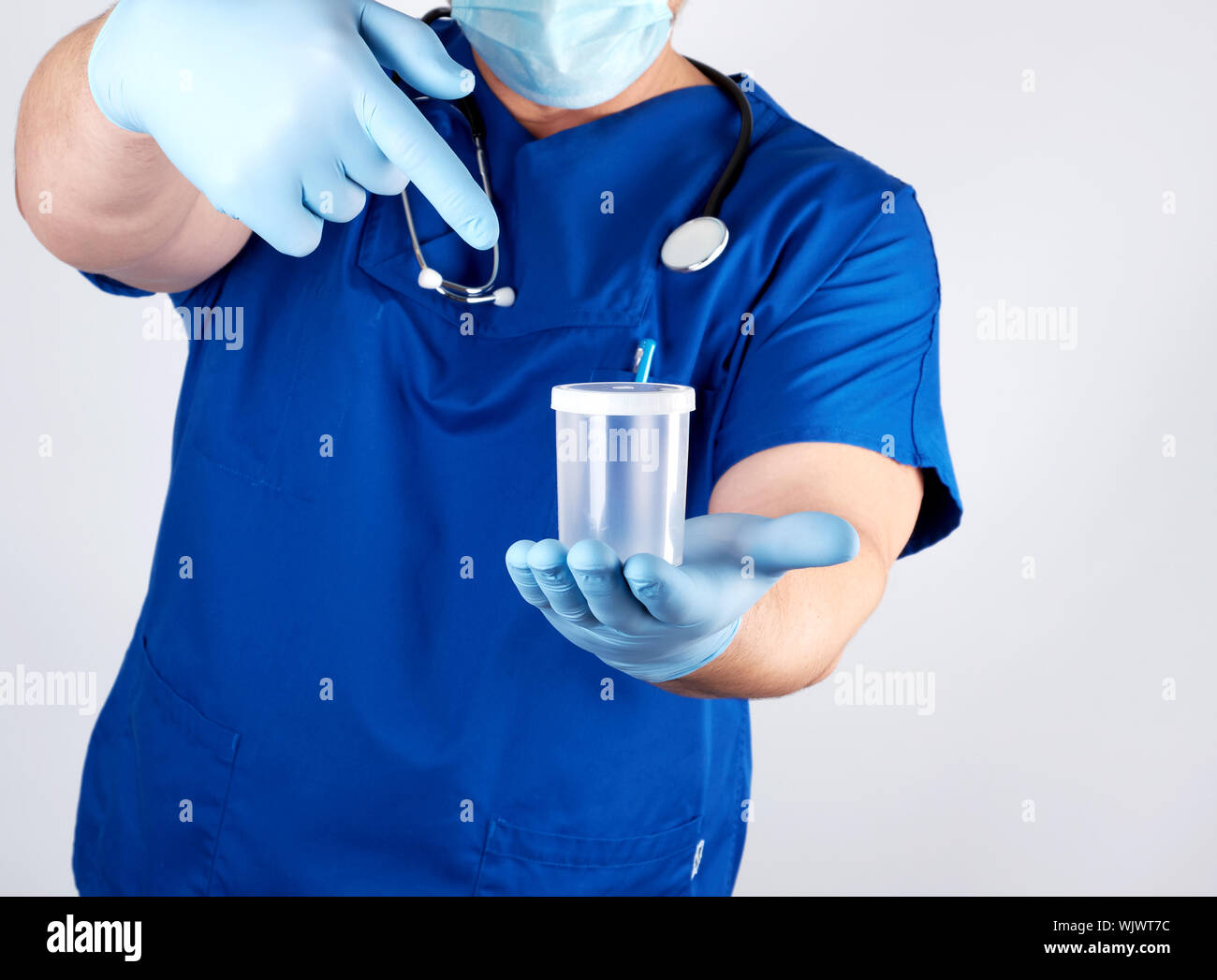 doctor in blue uniform and latex gloves is holding an empty plastic