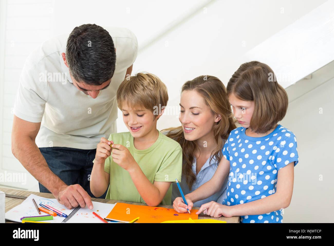 Happy family of four coloring at home Stock Photo - Alamy