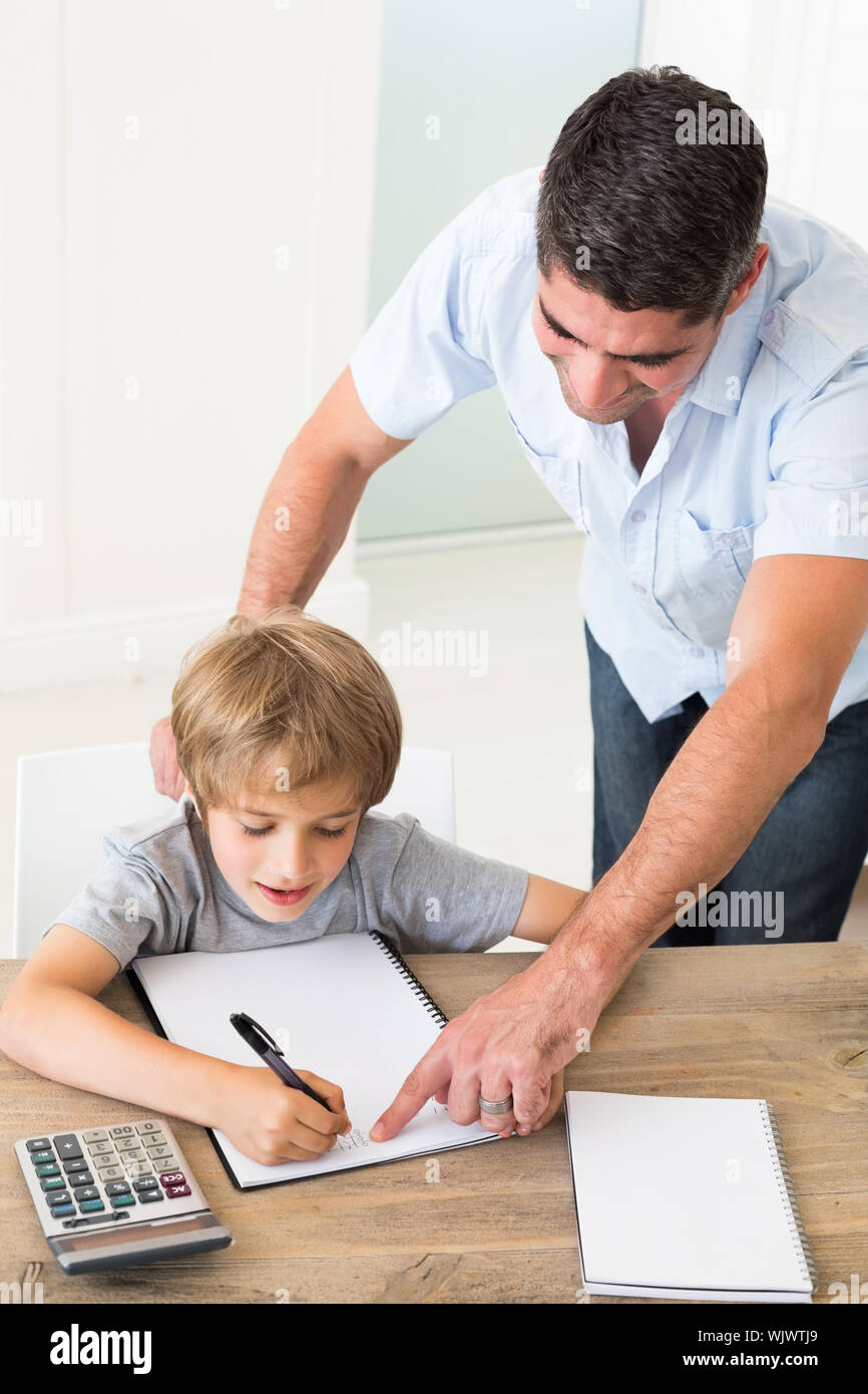 Father assisting boy in solving maths at home Stock Photo