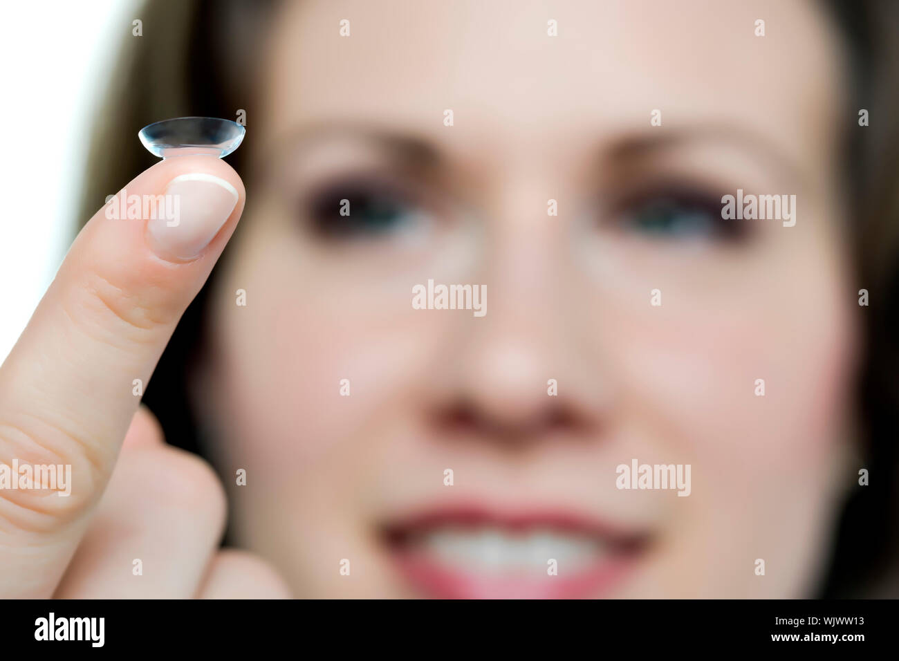 Closeup of a face of a woman with a contact lense on her finger Stock Photo