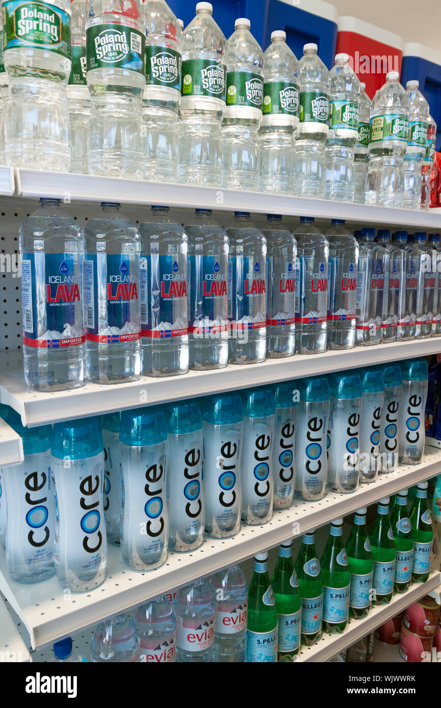 Various brands of bottled water for sale on store shelves. Stock Photo