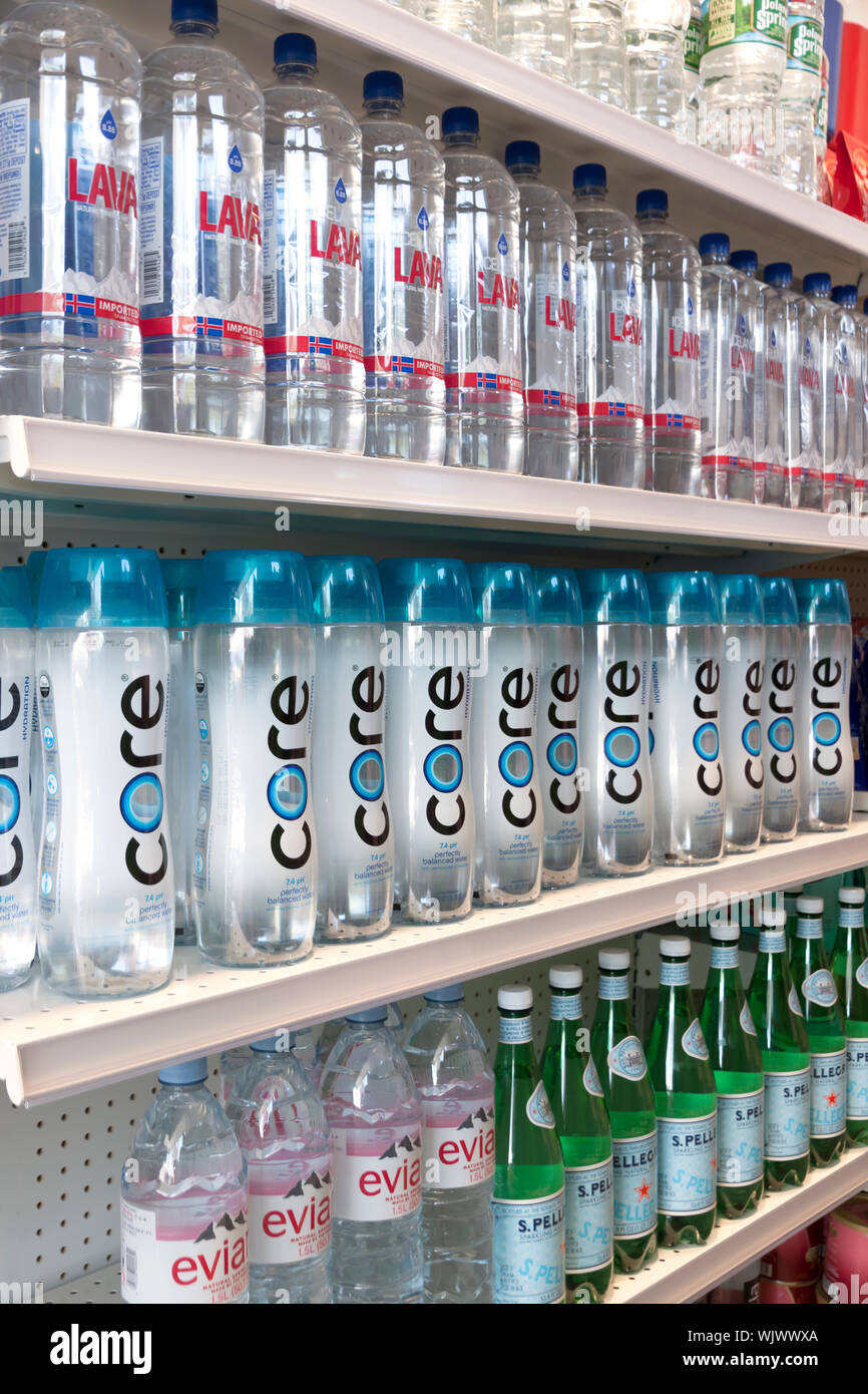 Various brands of bottled water for sale on store shelves. Stock Photo
