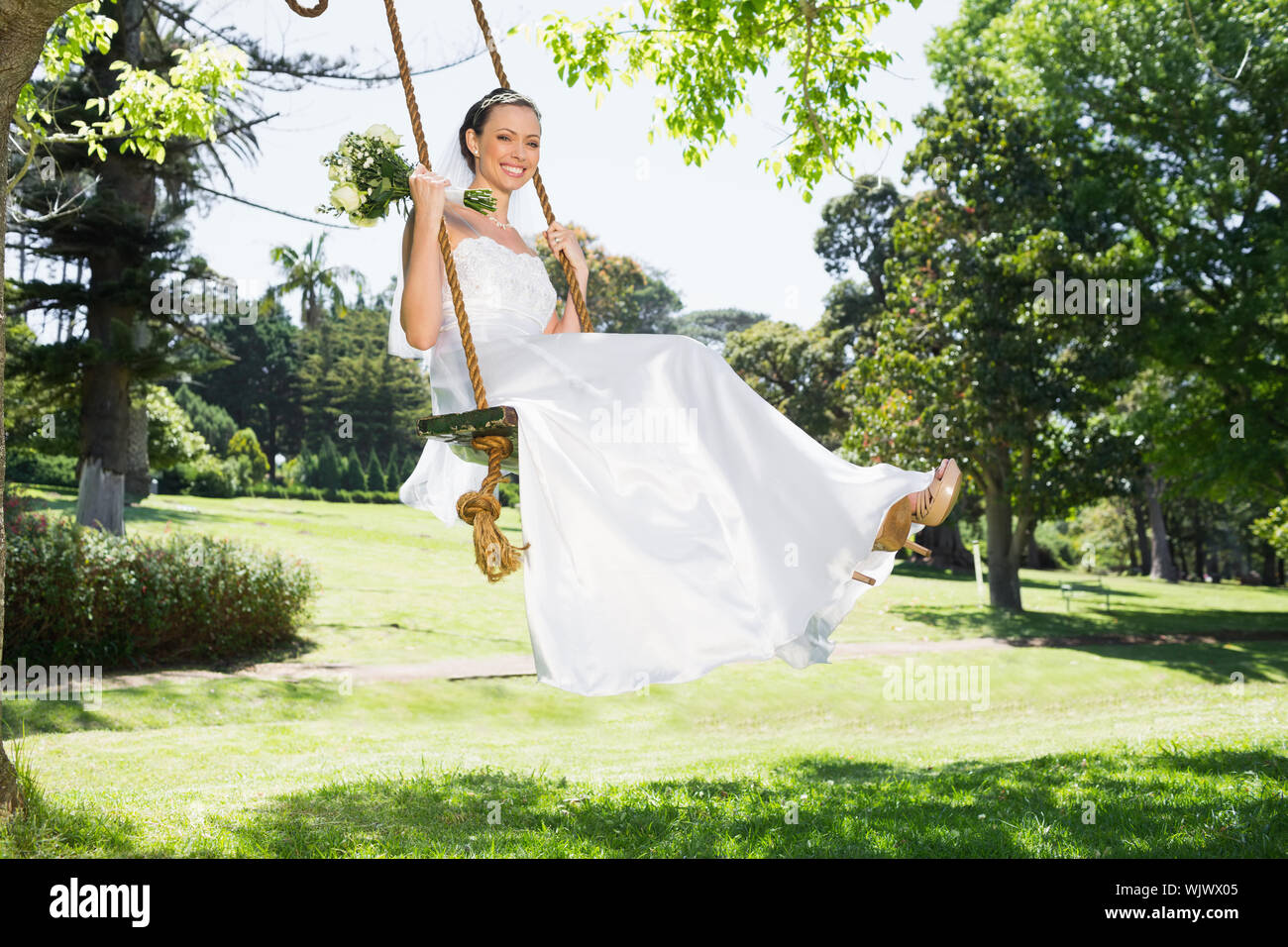 Happy woman swinging on rope hi-res stock photography and images - Alamy