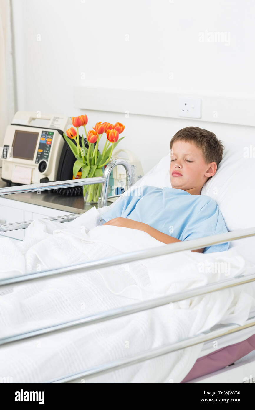 Sick little boy resting in hospital ward Stock Photo