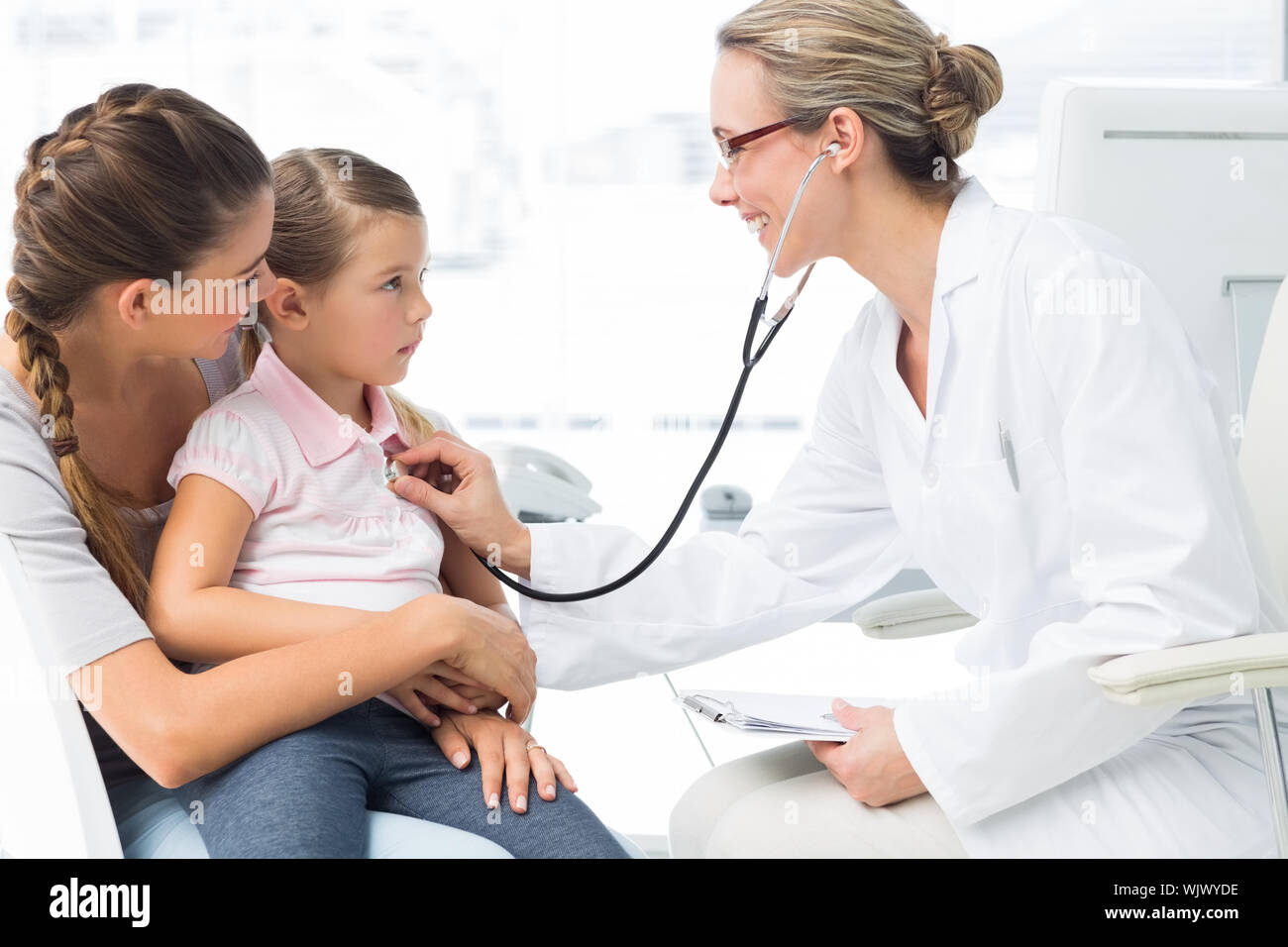 Mother with girl being examined by female doctor in clinic Stock Photo